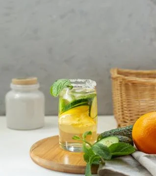 Cold refreshing water with cucumber, mint and lemon in a glass with a sugar r Stock Photos