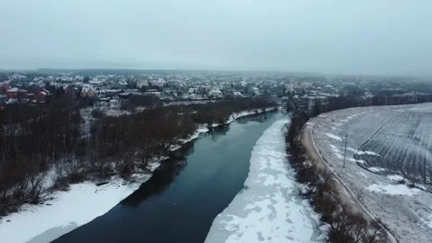 Cold river and snowy landscape in winter morning over the town near the water wi Stock Footage 329708351