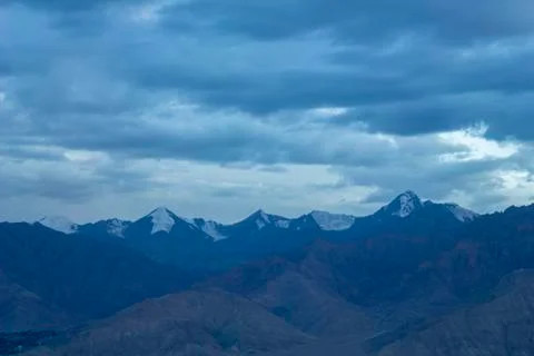 Cold sky over mountain snowy peaks in the evening Stock Photos