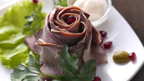 Cold sliced meat on a white plate with pomegranate seeds and sauce Stock Footage 164983917