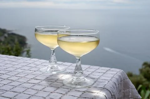 Cold sparkling wine, cava or champagne in two coupe glasses on table with s.. Stock Photos