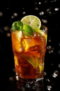 Cold tea with lemon and mint in water splashing Stock Photos