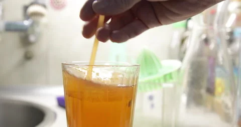 Cold tea mixed with lemon juice using drinking straw Stock Footage 231562049
