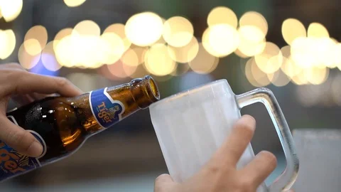 Cold tiger beer pouring from beer bottle into beer mug, slow motion 库存影片 106375155
