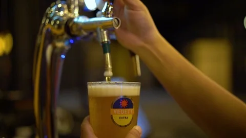 Cold vedett draft beer poured into glass from silver beer dispenser Stock Footage 106495212