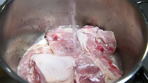 Cold water being added to a pot with chicken mea Stock Footage 139925205