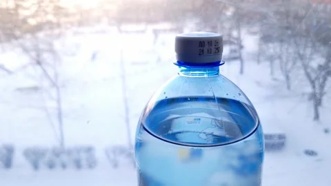 Cold Water Bottle on Windowsill with Snowy Winter View Stock Footage 326312877
