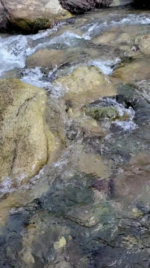 Cold water flowing over rocks Stock Footage 303990764