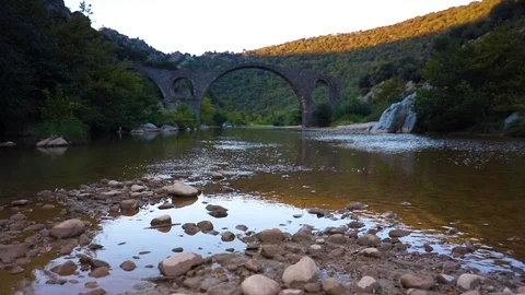 Cold water flowing in a stream under a medieval bridge Stock Footage 95217953