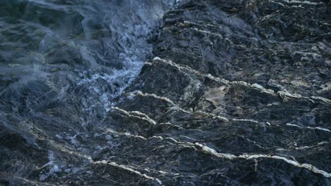 Cold water rolling over black rocks, 4k slow-mo Stock Footage 243536664