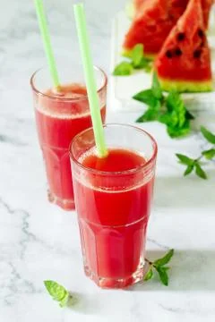 Cold watermelon lemonade with mint in a glass cup and slices of watermelon on a Foto stock