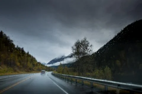 A cold wet day, low light, rain falling on the road, driver point of view. Stock Photos