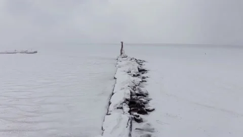 On a cold winter day in the north, there is a lighthouse frozen in ice. Stock-Footage 169983387