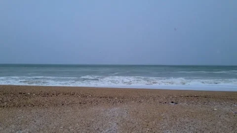 Cold winter sea waves rolling onto empty sandy beach coastline Stock Footage 328572297