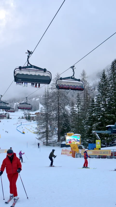 Colfosco, Italy - January 15, 2025: People moving through a ski resort near a Stock Footage 304403553