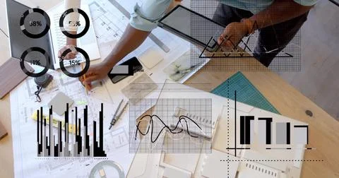 Collaborating architects sketching on drafting table, with blueprints, tablet Fotos de archivo