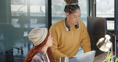 Collaborating on coding project, diverse female team using computers and Stock Footage 311495472