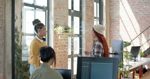 Collaborating on coding project, diverse female team discussing ideas at Stock Footage 311495509