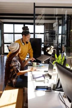 Collaborating on coding project, diverse women focused in modern office Foto stock