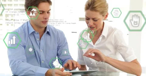 Collaborating colleagues in button-down shirts analyzing data on tablet at Foto stock