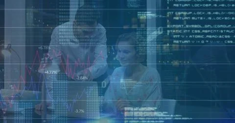 Collaborating colleagues reviewing code around laptop in night office, with desk Stock Photos