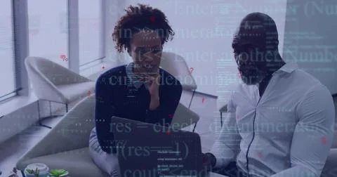 Collaborating colleagues reviewing code in office lounge, with laptop, coffee Stock Photos