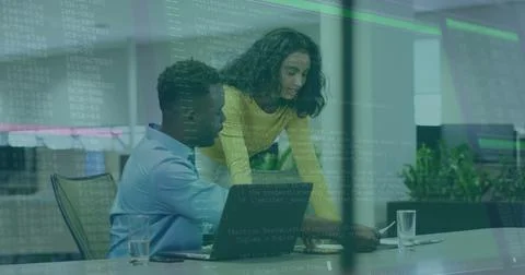 Collaborating developer and engineer pointing at code on laptop at open-plan Stock Photos