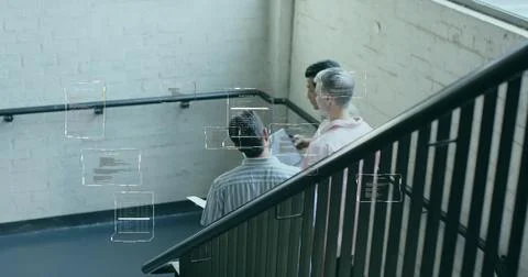 Collaborating developers viewing digital code overlays in office stairwell with 库存照片