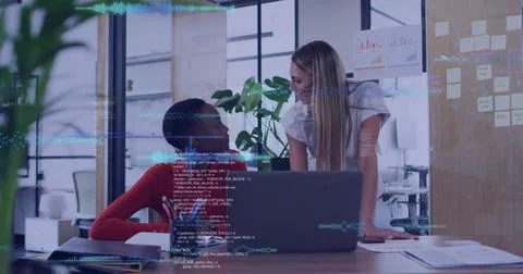 Collaborating developers wearing red sweater white blouse at office, with laptop Stock Photos