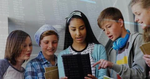 Collaborating five students coding on tablet in classroom, with notebooks and 스톡 사진