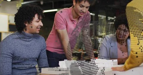 Collaborating group in studio attire arranging white models and foam mockups, Stock Photos