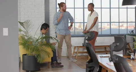 Collaborating in modern office, diverse team discussing project on tablet Stock Footage 315969154