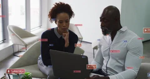 Collaborating pair in work clothes reviewing laptop in office lounge with 스톡 사진