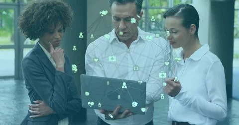 Collaborating professionals in suits examining data visualization in lobby, with 스톡 사진