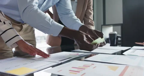 Collaborating on project, business team analyzing charts and graphs on table Stock Footage 340979571