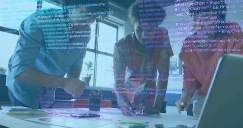 Collaborating software developers reviewing code on laptop at office desk, with 스톡 사진