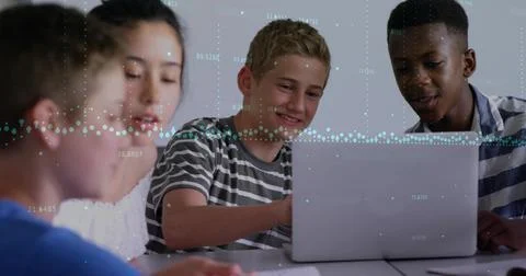 Collaborating students in striped shirts typing notes at study table with laptop Foto stock