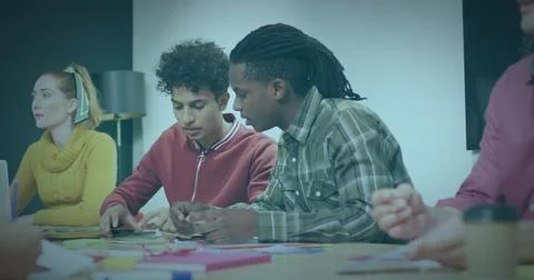 Collaborating team arranging colored paper and sticky notes in meeting room, Stock Photos
