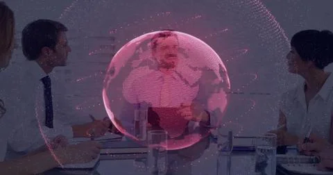 Collaborating team interpreting data on holographic globe projection in meeting 스톡 사진