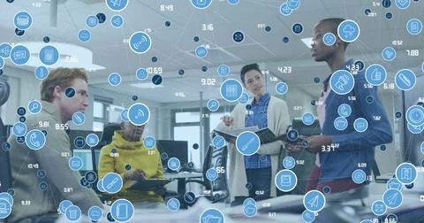 Collaborating team in jackets presenting at open-plan office, showing tablet, Stock Photos