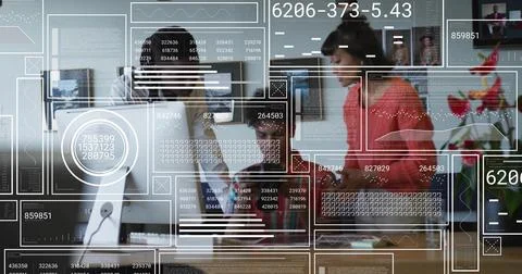 Collaborating team reviewing data on desktop in office with UI graphics, red 写真素材