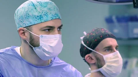 A collaborating team of surgeons performs surgery in a modern operating room. Stock Footage 270548145