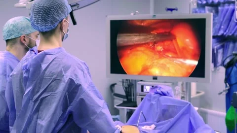 A collaborating team of surgeons performs surgery in a modern operating room. Stockbeeldmateriaal 270554108