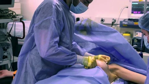 A collaborating team of surgeons performs surgery in a modern operating room. Stockbeeldmateriaal 270554876