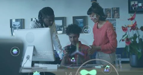 Collaborating three tech professionals coding with holographic icons at office Stock Photos