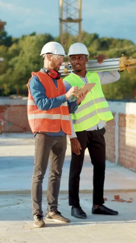 Collaboration on a Construction Site Involving Proper Safety Gear and Teamwork Stock Footage 316521607