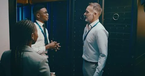 Collaboration, conversation and tech support with people in server room for Foto stock