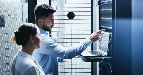 Collaboration, laptop and problem solving with people in server room for network Stock Photos