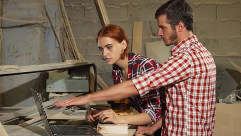 Collaborative carpenters engaged in digital planning at their workshop Stock Footage 311657710