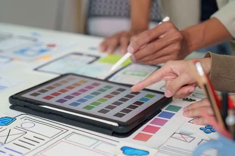 Collaborative Design. Team brainstorming on digital interface mockups and color Stock Photos